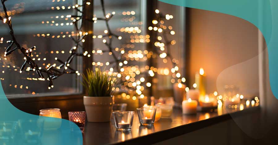 Windowsill with holiday lights and candles. Safe Holiday Season with homeowners insurance.